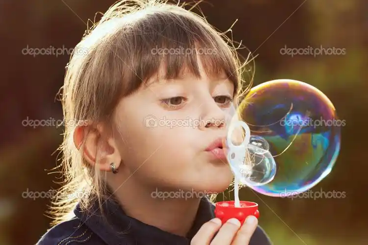 little girl inflates a big bubble