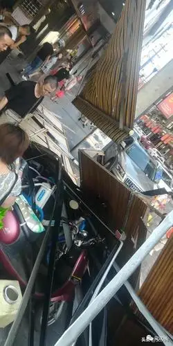 左右南充三公街一广告牌从三楼掉落,砸在了一辆小车上,多辆电瓶车被砸