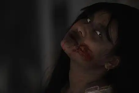 亚洲女鬼带血的特写脸和眼睛.在黑暗的房子里恐怖令人毛骨悚然的恐惧.