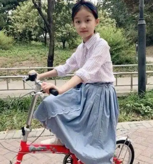 从照片中看,小四月穿着白色条纹衬衫,浅蓝色牛仔长裙,美丽的像个小