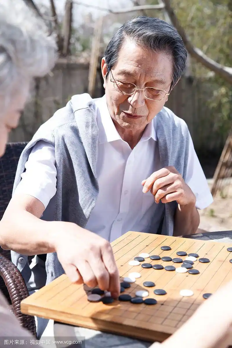 老年夫妇在庭院下棋