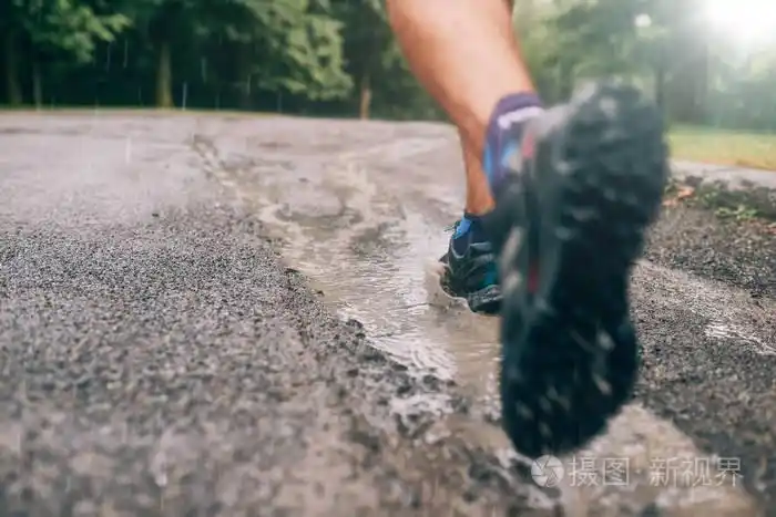 肌肉的犊牛的健康男性慢跑训练跨国家森林小道赛跑在雨中对自然教育径