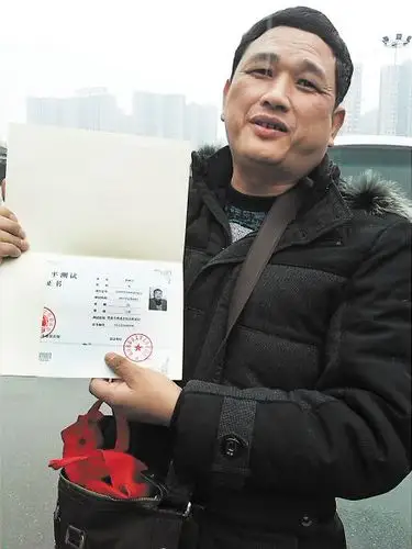 图为曹湘凡向记者展示自己未达标的普通话等级证书.