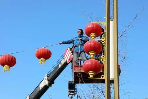 施工现场,小编看到工人师傅们站在升降机斗里,利用道路两侧的路灯把