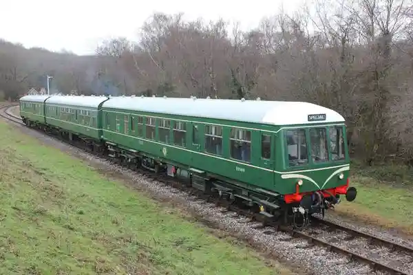 a train traveling down train tracks next to a green field