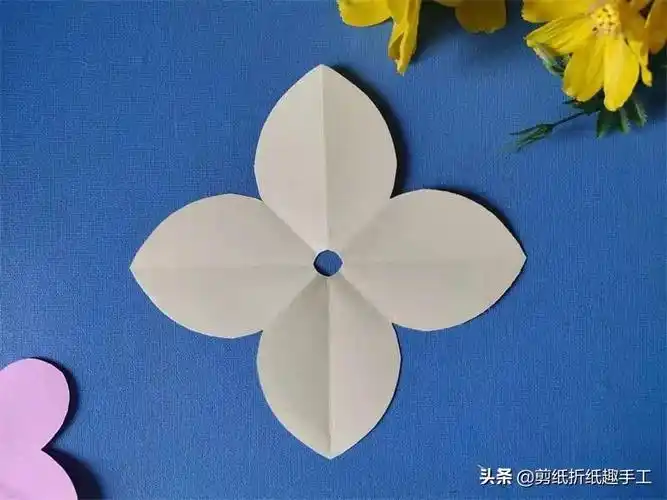 6,展开剪好的彩纸,四个花瓣的窗花便剪好了,原理便是八个半瓣组成四个