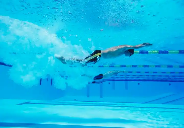 在游泳池中游泳的三个男运动员游泳比赛