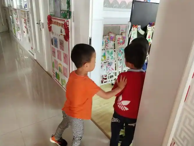 瞧,宇宇把小朋友往教室里推呢,还边说:"不能跟陌生人走".