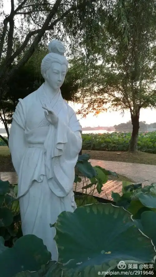 汉白玉的白娘子雕塑矗立在荷塘边,晨曦初照,栩栩如生.