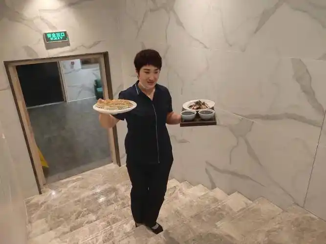 刘总帮餐厅服务员上菜.