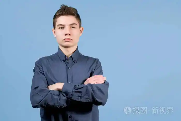 一个双臂交叉放在胸前的少年站着表情严肃靠近镜头模仿空间