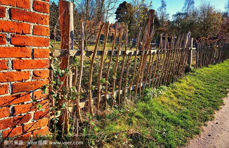 砖墙上的旧木篱笆.