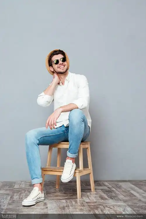 坐在木凳上戴着墨镜微笑的男士高清图片