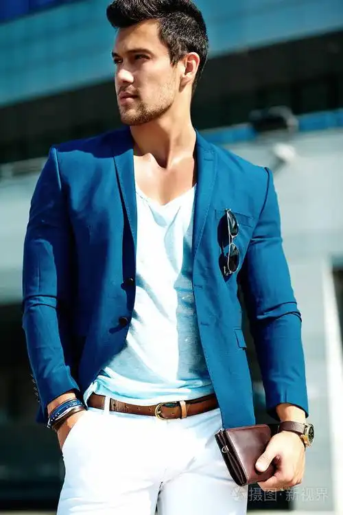 性感英俊时尚男模特穿着优雅西装在街头摆姿势的肖像