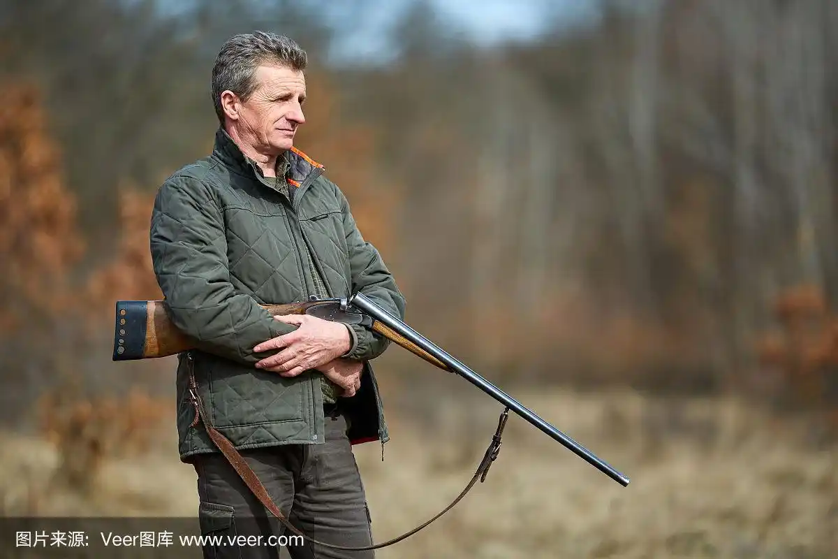 猎人拿着枪在森林里