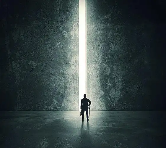 站在开启墙体大门前面的男人