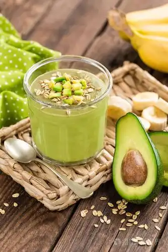 牛油果和香蕉奶昔燕麦与木制背景上的玻璃罐中的成分