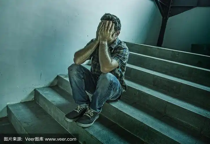 戏剧性的生活方式肖像年轻的抑郁和悲伤的男人独自坐在户外在黑暗的