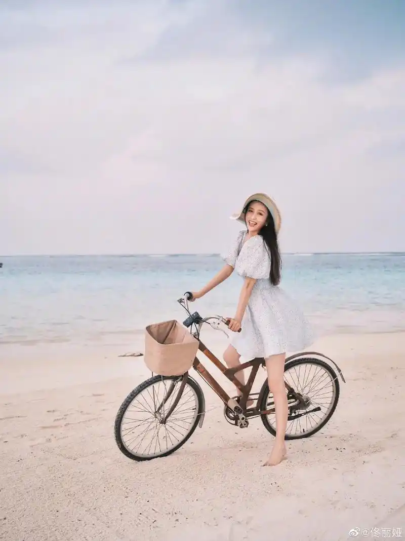 佟丽娅大年初五晒出一组海边写真穿着泡泡袖连衣裙光着脚丫骑着单车