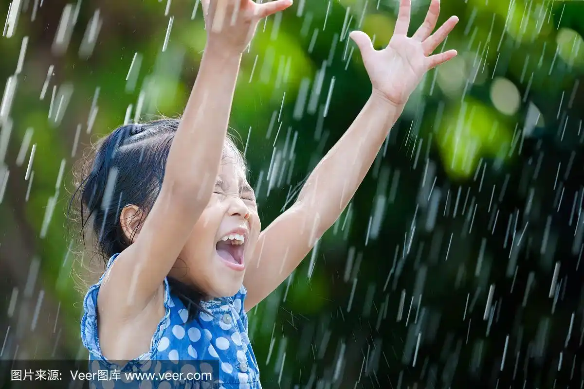 快乐的亚洲小女孩玩雨的乐趣