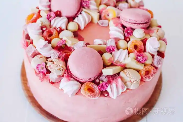 粉色蛋糕从糖果, 马卡龙, 棉花糖, 白巧克力装饰.甜蜜的生日礼物.