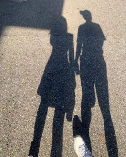 杨奇煜晒出两张照片,其中一张是杨奇煜和妻子在阳光下的影子照,两人并