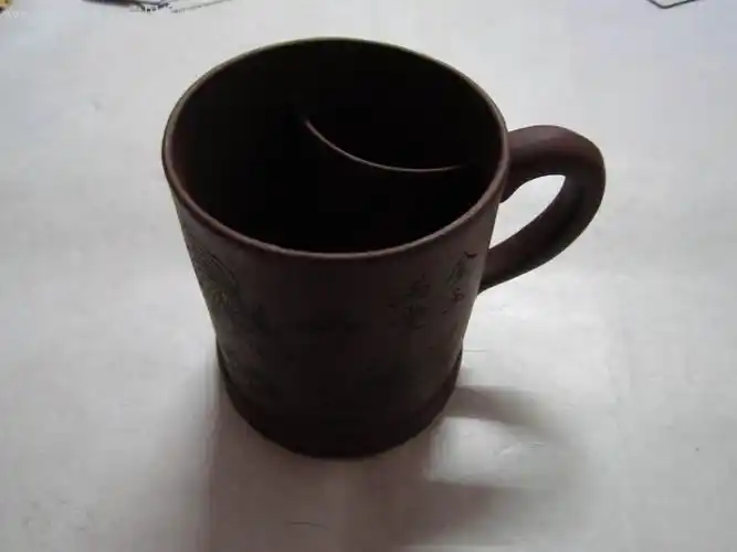 一把紫砂杯(底部有"宜兴紫砂珍藏品蒋祥君制陶"字样)