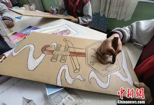 小学生巧手变废为宝用纸板刻画民族风情