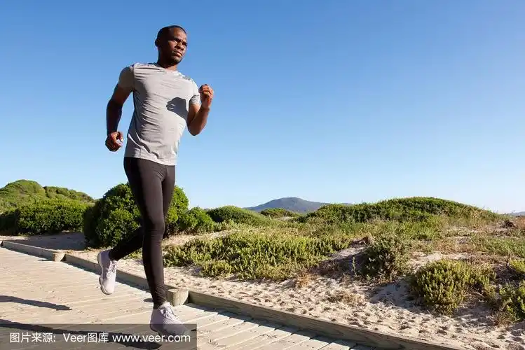 健身男模在海滩上跑步