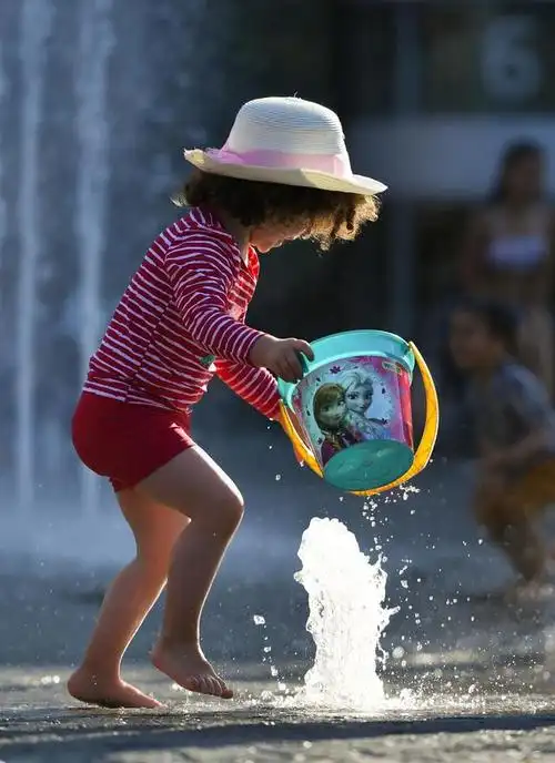 8月8日,一名儿童在德国法兰克福一处喷泉内戏水.