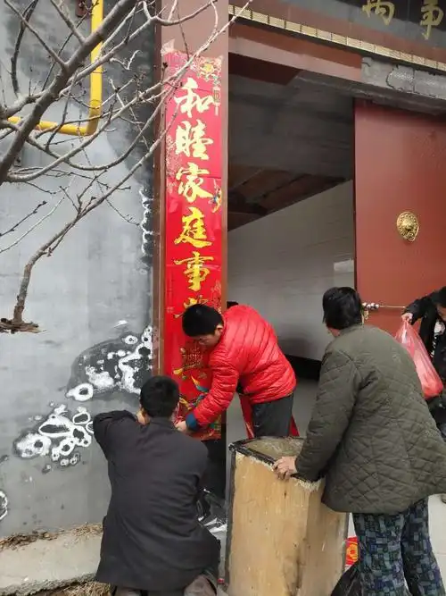 全家老少齐上阵,和睦美满度春节.常博伦同学帮助家人贴春联.