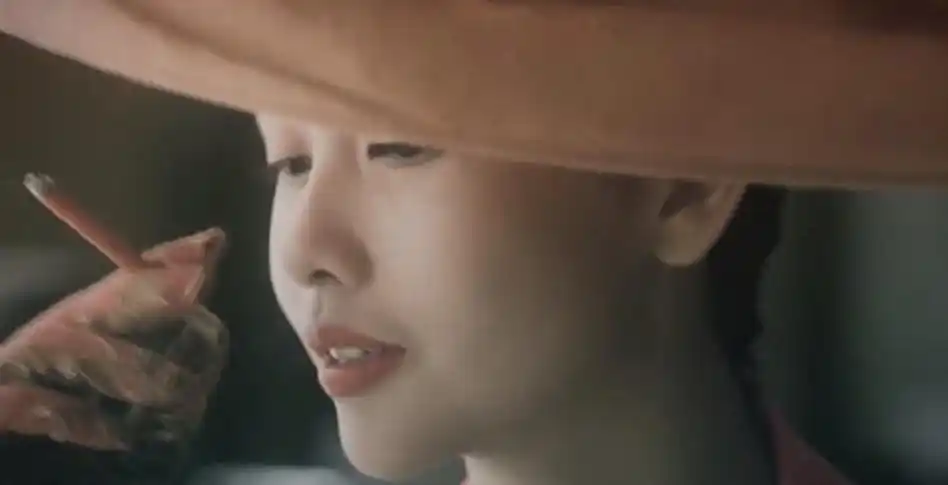 邱淑贞戴着红色宽檐礼帽,手夹红色香烟,低眉红唇,这张侧脸杀凸显