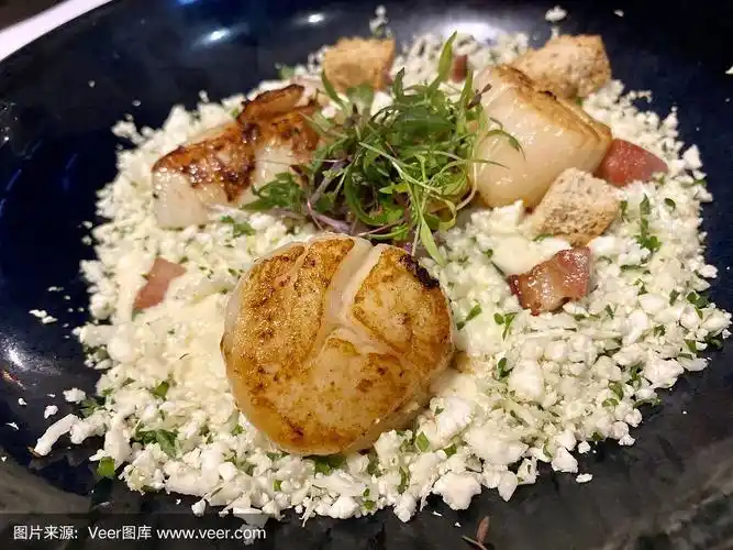 high angle closeup view of three sautéd scallops  served on a