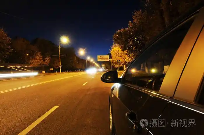 黑色的汽车在路在黑暗的夜城市与灯