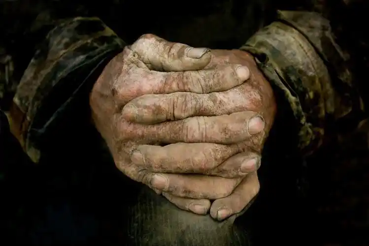 粗糙的双手,正盘在膝盖上小憩,他就是我们当今的城市缔造者农民工