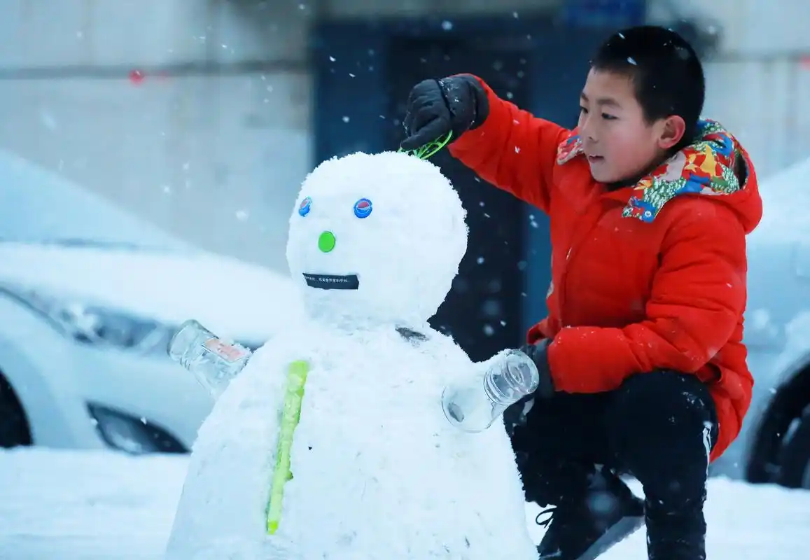 一名小男孩在雪地里堆雪人