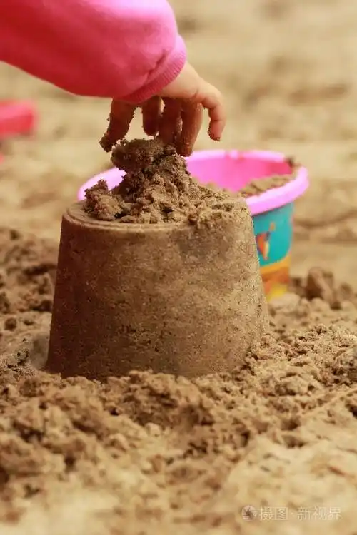 孩子的手在沙箱中砂疗法通过玩堆沙堡