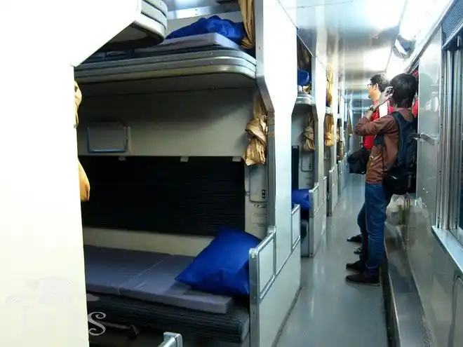 (p7,舒适干净的火车卧铺,二等车厢,每个床头有台灯和电源插座)