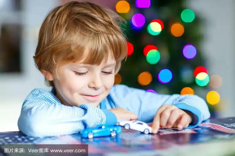 金发小孩在家里玩汽车和玩具