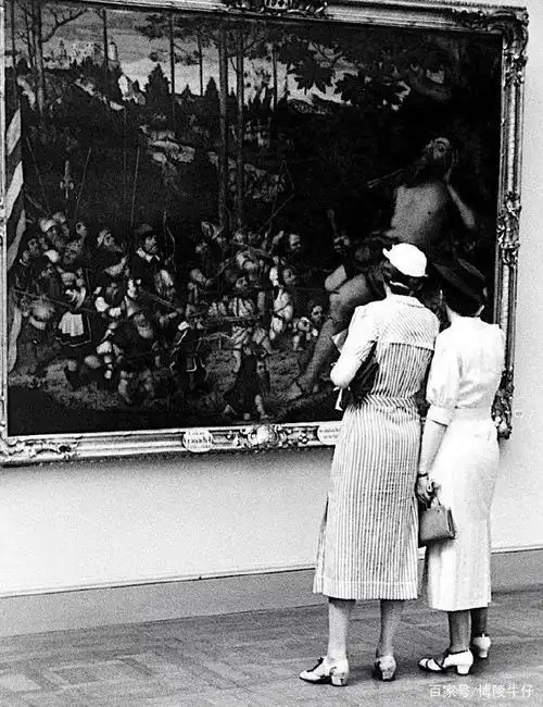 1937年德国两位穿着时尚的女郎,她们在讨论一副油画. 举报/反馈