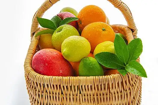 装在篮子里新鲜的综合水果在白色的背景