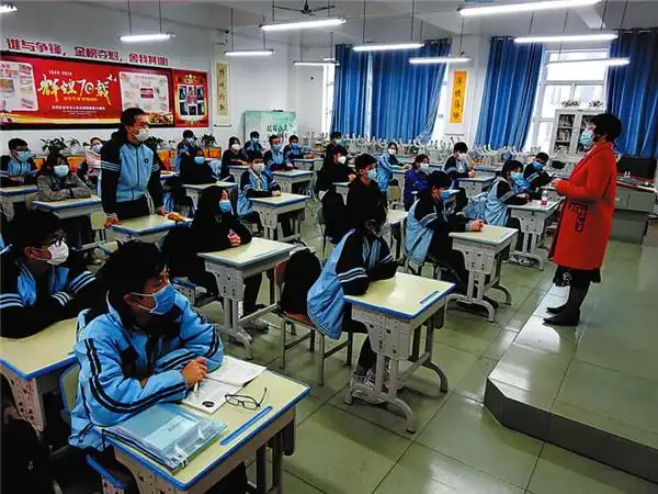 在南宁二中初中部教室里,学生单人单座,间隔1米,戴口罩上课 记者赖有