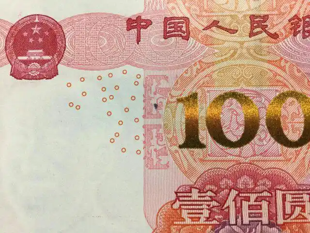 刚刚发行的2015版百元人民币上有一个印刷污点,黑点在纸中间夹着摸