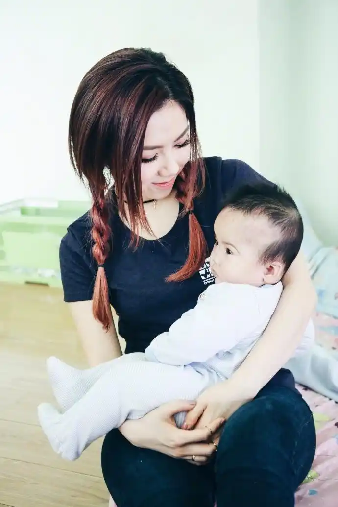 组图:邓紫棋探访患病儿童 扎麻花辫露甜笑尽显清纯