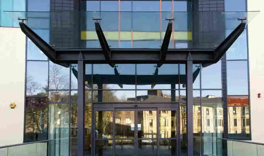 办公写字楼进门口玻璃遮阳雨篷设计图片 商场阳光板雨棚安装效果图