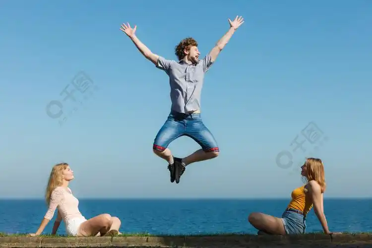 无忧无虑的年轻朋友们在海水中快乐的人跳起来玩得开心夏天的快乐和