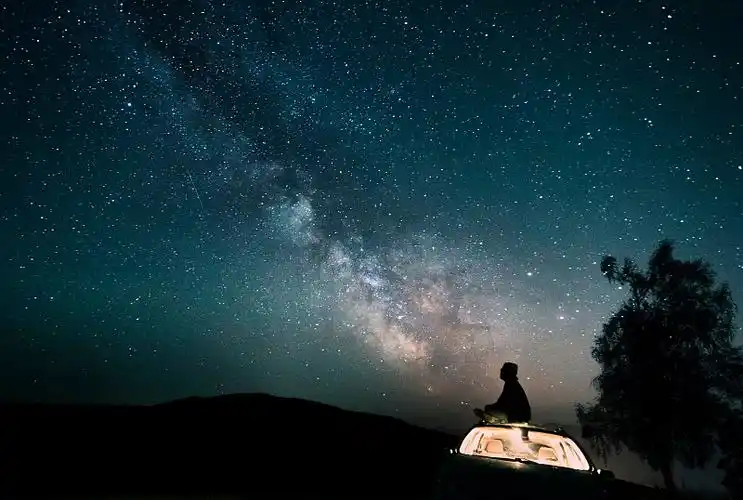 奥地利,蒙西,在星空下,一个人坐在车顶的剪影图片下载