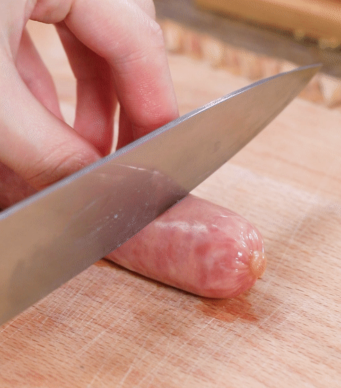 切好的吐司条铺上一层奶酪碎,再放上香肠段.