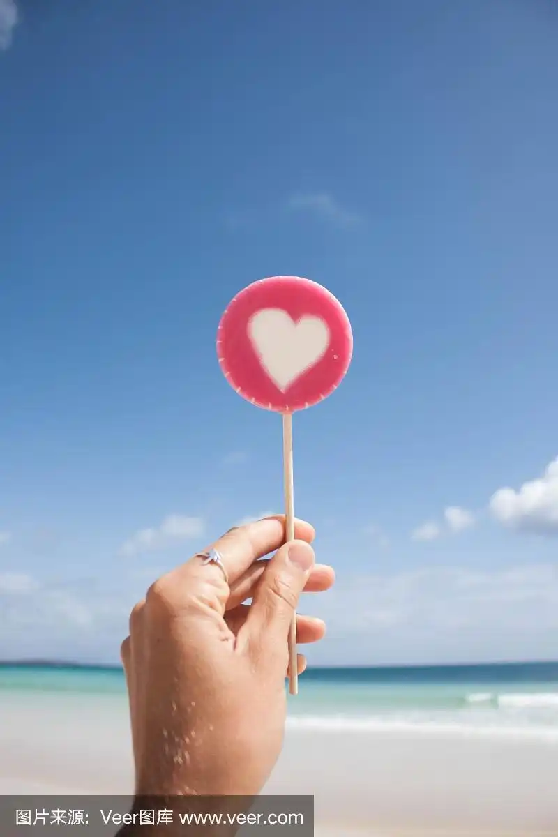 在海滩上手里拿着棒棒糖