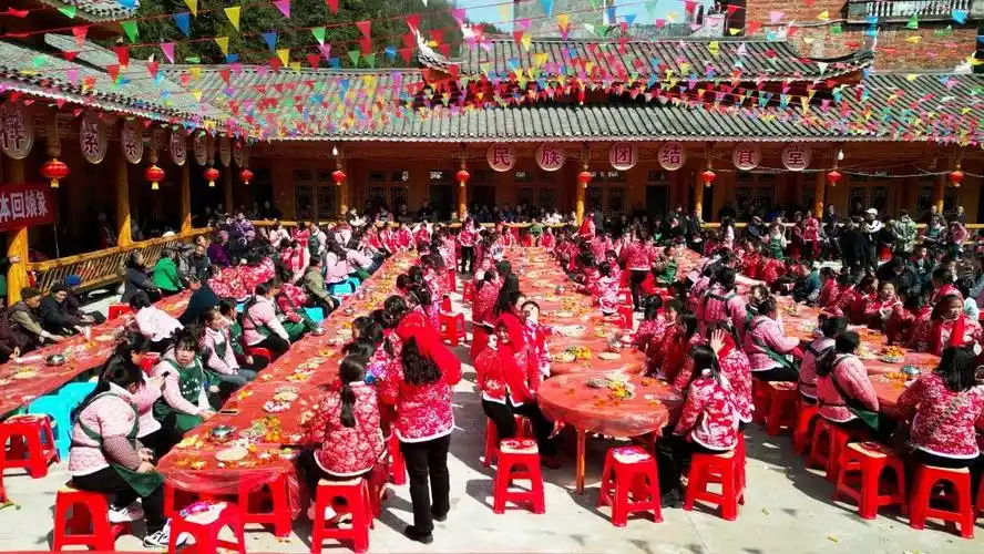 "姑妈"队伍最前面举着回娘家的横幅,行走在进村寨的途中宛如一条长龙